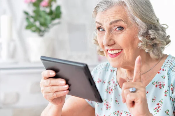 老妇女的画像与平板电脑指向 — 图库照片