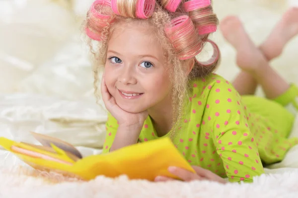 Preciosa Niña Con Rizadores Rosados Leyendo Cama Casa —  Fotos de Stock