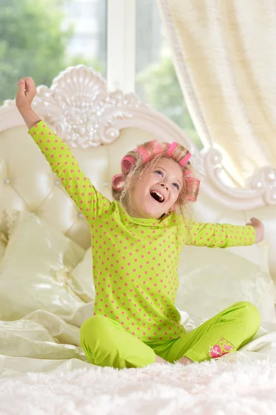 Preciosa Niña Con Rizadores Rosados Divirtiéndose Cama Casa — Foto de Stock