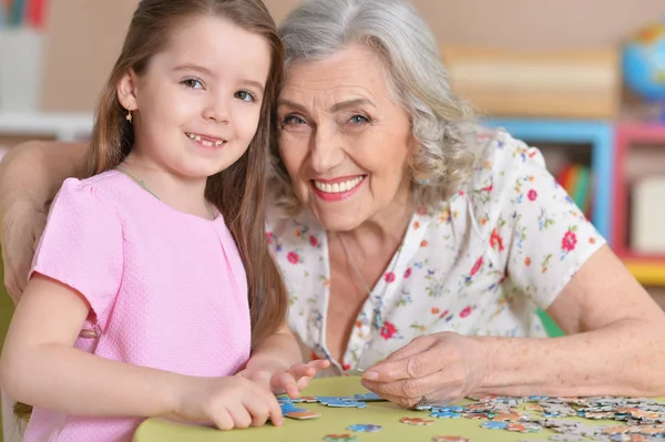 Meisje verzamelen puzzels — Stockfoto