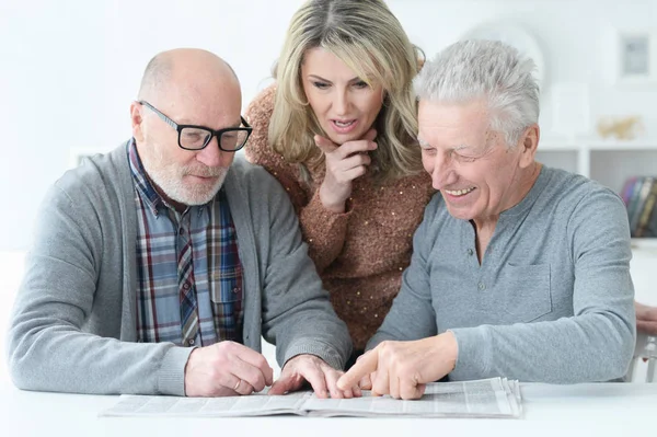 Personas Mayores Sentadas Mesa Leyendo Periódico —  Fotos de Stock