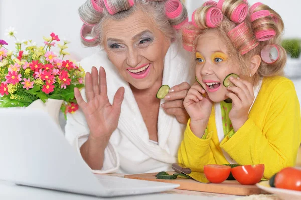 Senior woman and girl using laptop — Stock Photo, Image