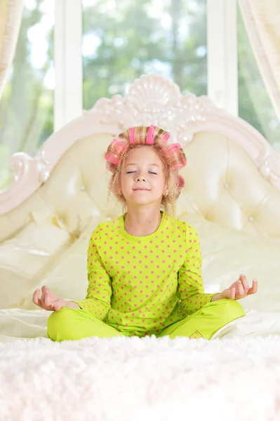 Preciosa Niña Con Rizadores Rosados Meditando Cama Casa —  Fotos de Stock