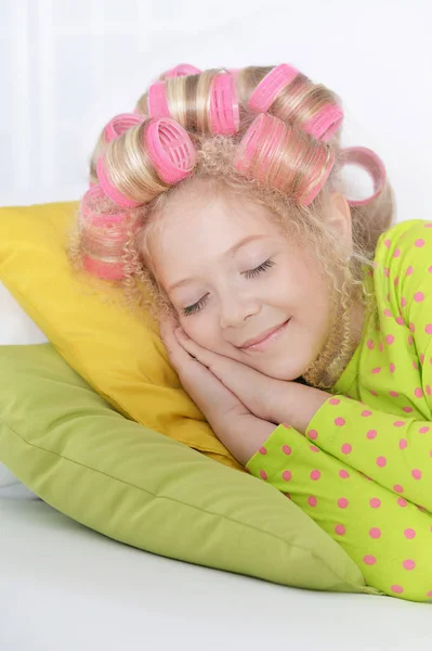 可爱的小女孩与粉红色的卷发睡在家里 — 图库照片