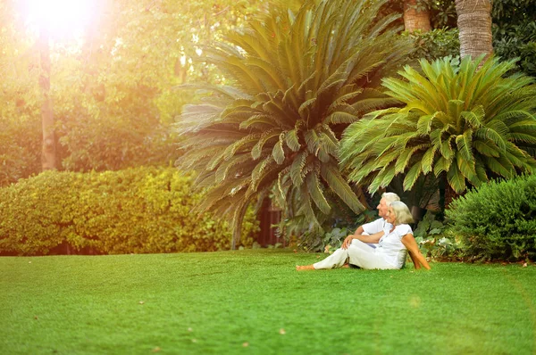 緑の草原に座って幸せな先輩カップル — ストック写真