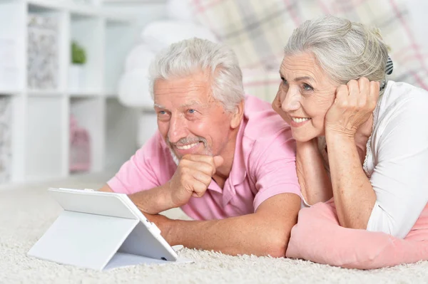 一对快乐的老夫妇在家中使用平板电脑的肖像 — 图库照片