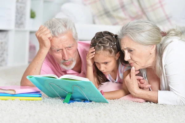 祖父母の小さな孫娘の本を読んで — ストック写真