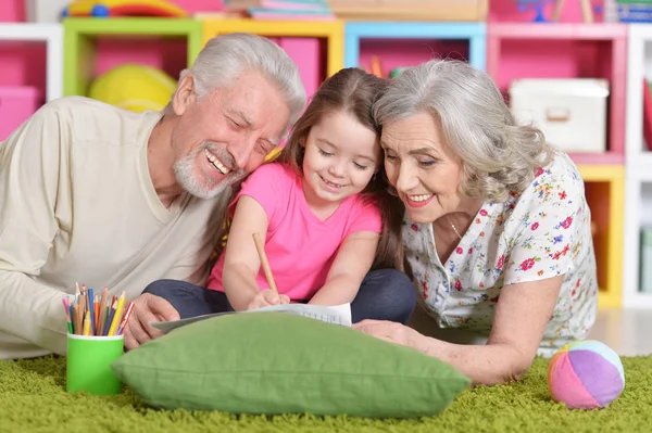 Großeltern Zeichnen Mit Ihrer Enkelin Auf Dem Boden Liegend — Stockfoto