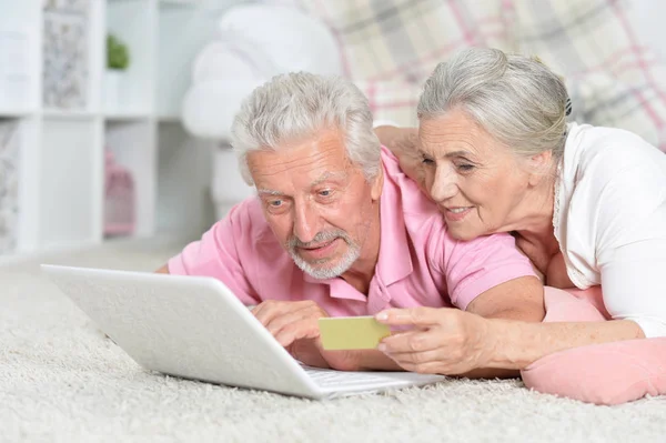 快乐的资深夫妇使用笔记本电脑在家里购物在线 — 图库照片