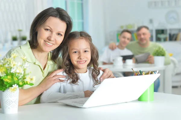 Linda Niña Madre Sentadas Mesa Usando Portátil Moderno —  Fotos de Stock