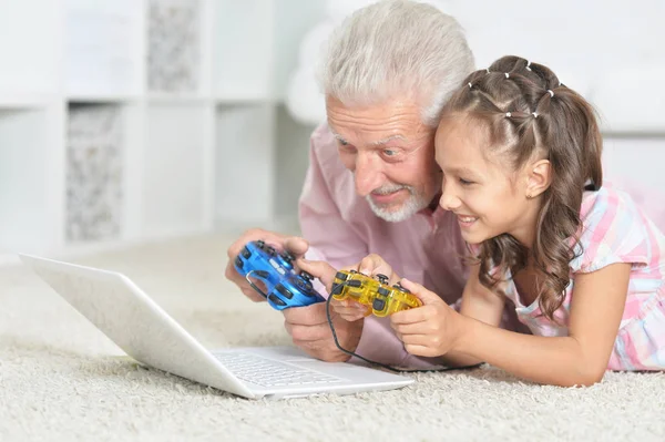 情感祖父和孙女玩电脑游戏与笔记本电脑 — 图库照片