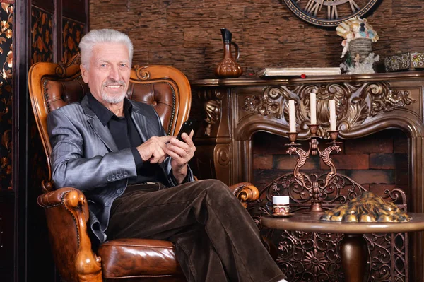 Sonriente Hombre Mayor Con Teléfono Mientras Está Sentado Silla Vintage — Foto de Stock