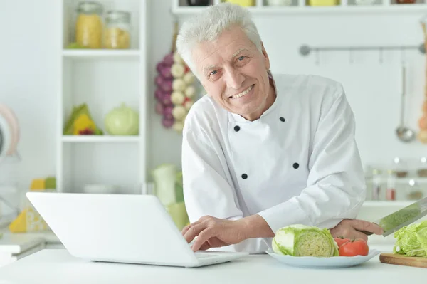 Chef Masculino Edad Avanzada Que Utiliza Ordenador Portátil Mientras Cocina —  Fotos de Stock