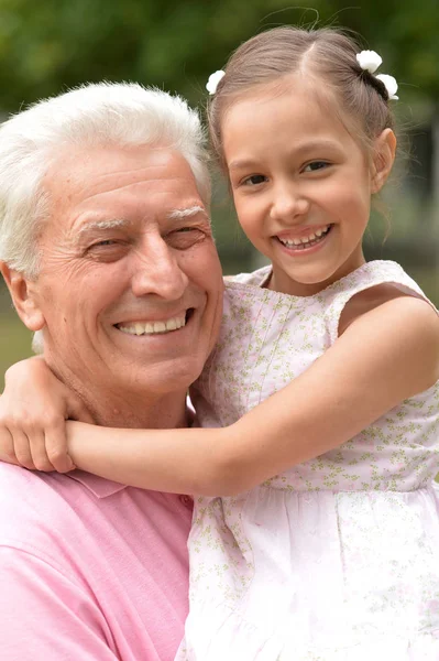 春パークで孫娘と幸せな高齢者男 — ストック写真