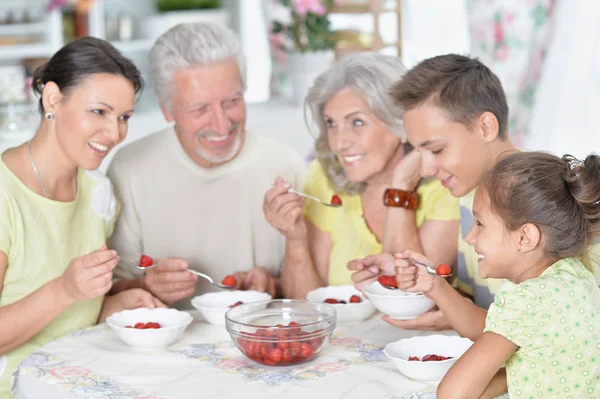 キッチンで新鮮なイチゴを食べて幸せな大家族 — ストック写真