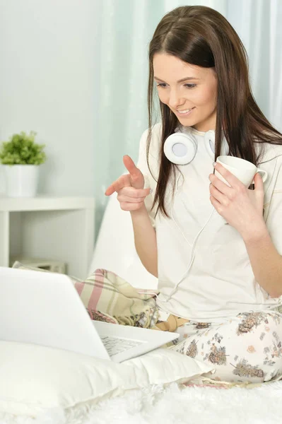 Mladá žena s sluchátka a laptop — Stock fotografie