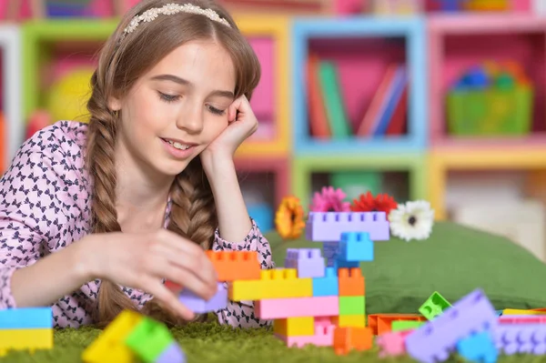 Kıvırcık Kız Yerde Yatarken Renkli Plastik Bloklarla Oynama — Stok fotoğraf