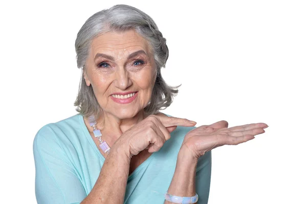 Портрет Красивой Пожилой Женщины Указывающей Ладонь Белом Фоне — стоковое фото