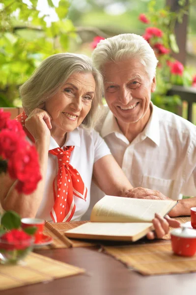 Gelukkig Senior Paar Lezen Boek Terwijl Het Drinken Van Koffie — Stockfoto