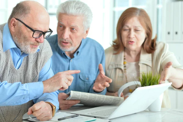 Parejas mayores leyendo el periódico — Foto de Stock