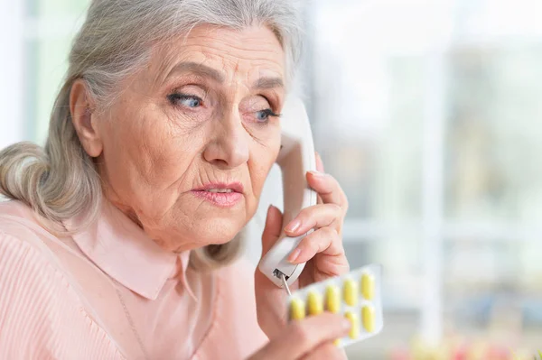 Больная Пожилая Женщина Звонит Доктору Дома — стоковое фото