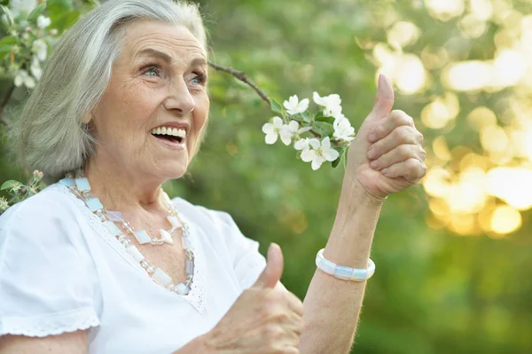 Happy Senior Beautiful Woman Spring Park Showing Thumb — Stock Photo, Image