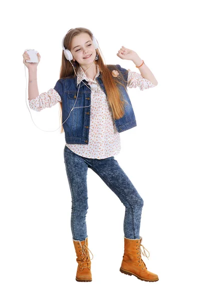 快乐的小女孩牛仔裤听音乐与智能手机在白色背景下隔离 — 图库照片