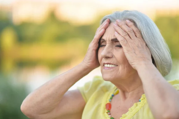 Mujer Hermosa Senior Con Dolor Cabeza Parque Primavera —  Fotos de Stock