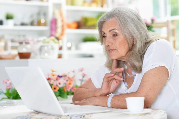 Nachdenkliche Seniorin Nutzt Laptop Hause — Stockfoto