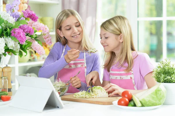 Zwei Mädchen Rosa Schürzen Bereiten Salat Auf Küchentisch Mit Tablet — Stockfoto