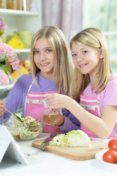 Twee Meisjes Roze Schorten Bereiden Salade Keukentafel Met Tablet — Stockfoto