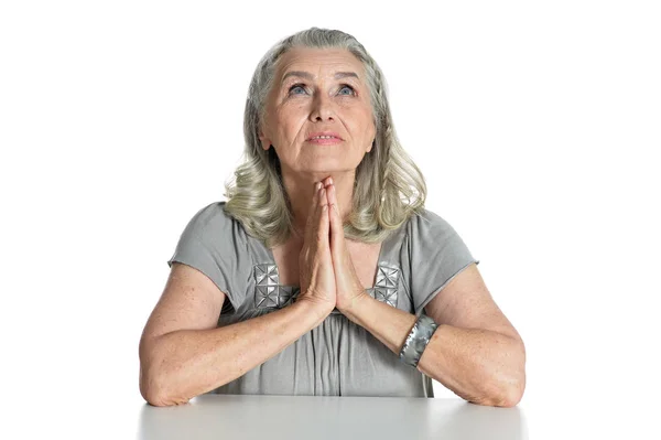 Emotional Senior Woman Praying While Sitting Table Isolated White Background — Stock Photo, Image