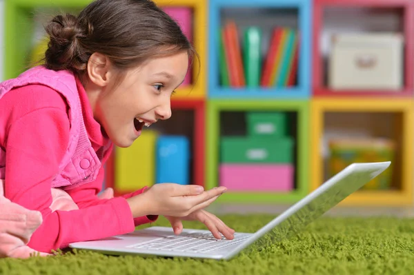 Menina Bonito Emocional Usando Laptop Enquanto Deitado Chão Verde Casa — Fotografia de Stock