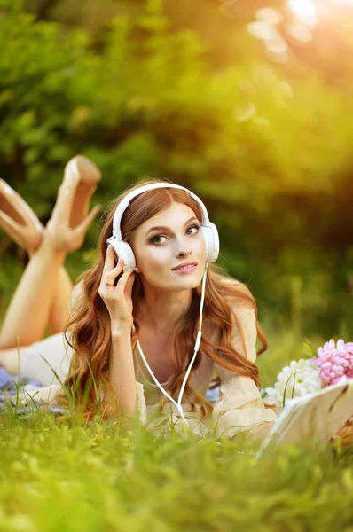 Hermosa Mujer Joven Acostada Prado Verde Escuchando Música Desde Tableta —  Fotos de Stock