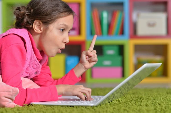 Menina Bonito Emocional Usando Laptop Enquanto Deitado Chão Verde Casa — Fotografia de Stock