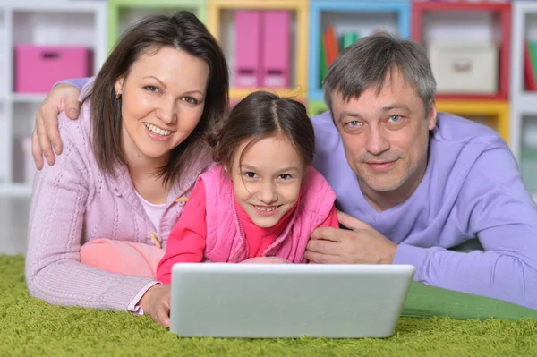 微笑的父母和女儿在房间里使用笔记本电脑 — 图库照片