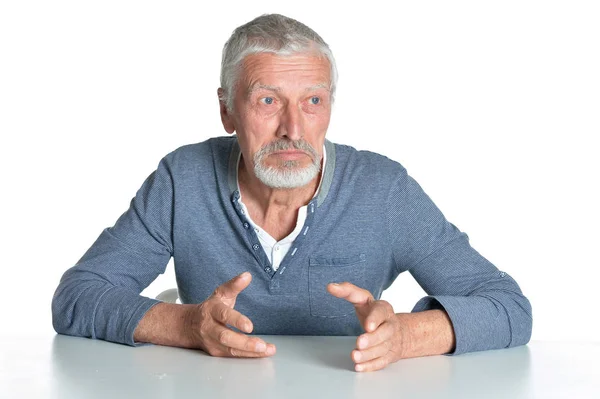 Retrato Homem Sênior Sentado Mesa Isolado Fundo Branco — Fotografia de Stock