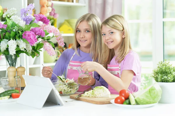 Two Girls Pink Aprons Preparing Salad Kitchen Table Tablet — Stock Photo, Image