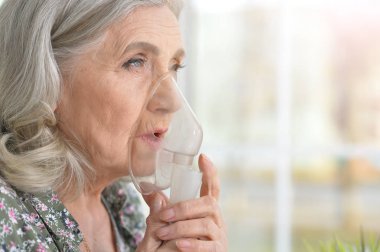 Portrait of elderly woman with flu inhalation clipart