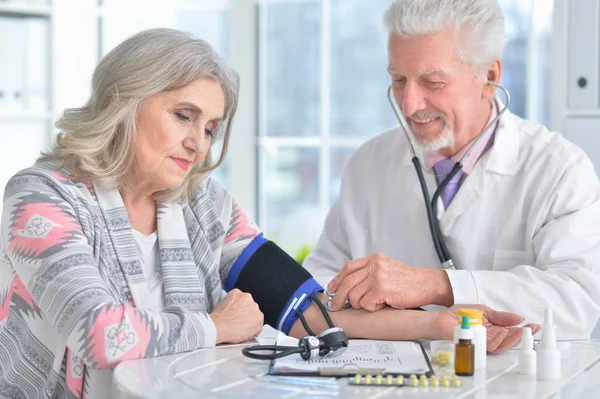 Starší doktor měření krevního tlaku — Stock fotografie