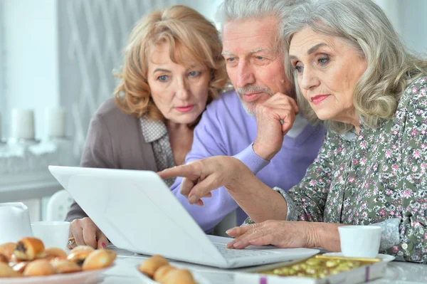 快乐的老年人与笔记本电脑在厨房喝茶 — 图库照片