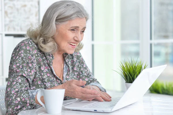 Emotionele senior vrouw met laptop — Stockfoto