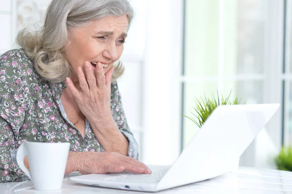 Emotionale Seniorin mit Laptop — Stockfoto