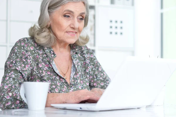 Эмоциональная пожилая женщина с ноутбуком — стоковое фото