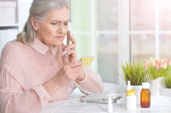 Kranke Seniorin Sitzt Hause Tisch Und Ruft Arzt — Stockfoto