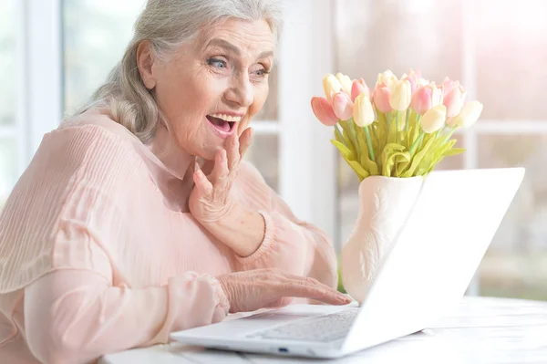 Счастливая Пожилая Женщина Использует Ноутбук Дома — стоковое фото