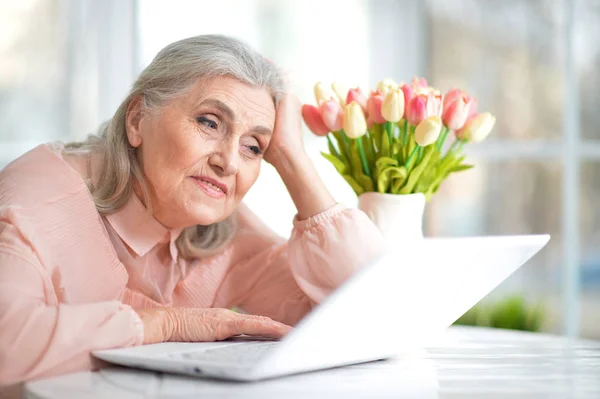 Evde Dizüstü Bilgisayar Kullanan Mutlu Bir Yaşlı Kadın — Stok fotoğraf