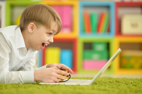 Мальчик Играет Видеоигру Ноутбуке Лежа Полу — стоковое фото