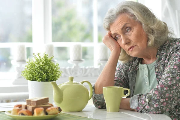 Schöne Traurige Seniorin Trinkt Tee Während Sie Küchentisch Sitzt — Stockfoto