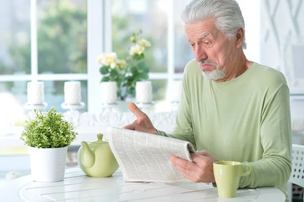 Känslomässiga Senior Man Läsa Tidningen Hemma — Stockfoto